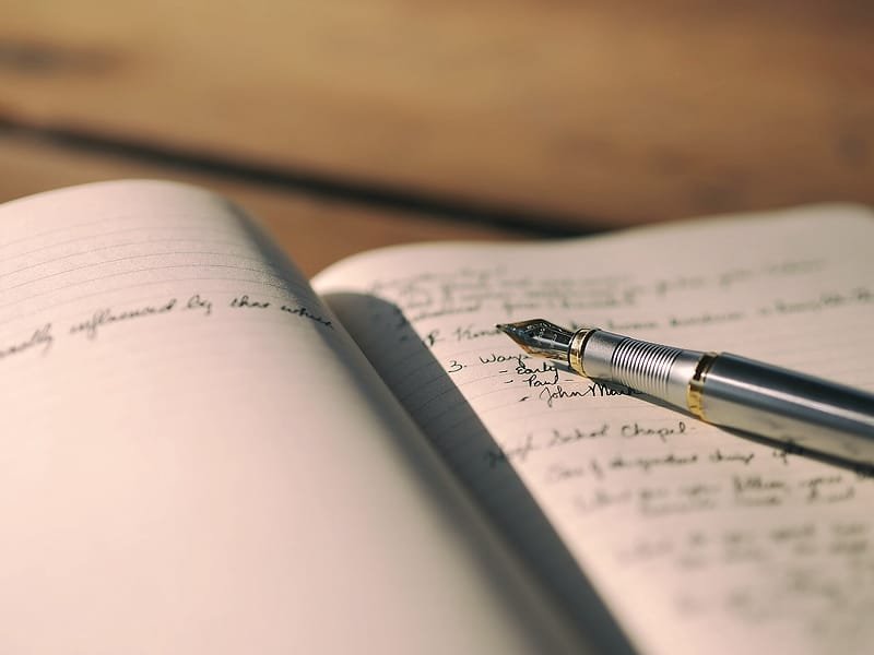 A fountain pen resting on a handwritten page