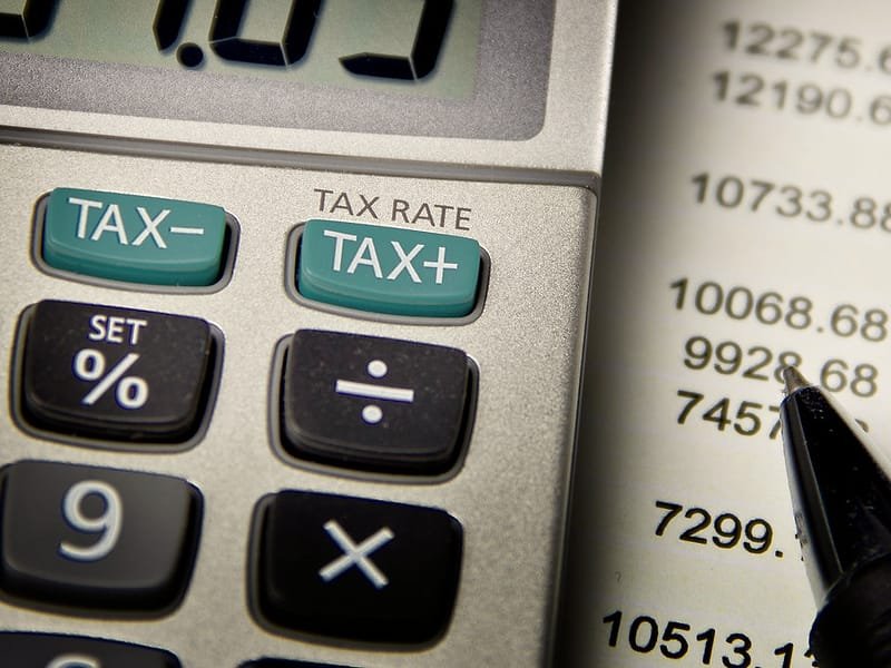Calculator keys marked Tax+ and Tax- beside printed figures